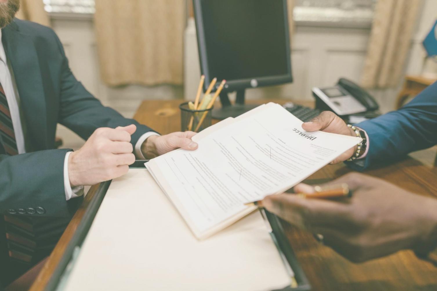 Professionisti che studiano documenti contrattuali in un ambiente di lavoro moderno